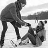 Man helping ice skating woman up on icy surface of frozen lake, Cologne, NRW, Germany